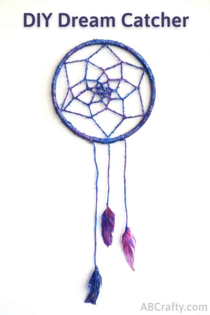 Finished galaxy dream catcher with feathers, blue, purple, and glitter