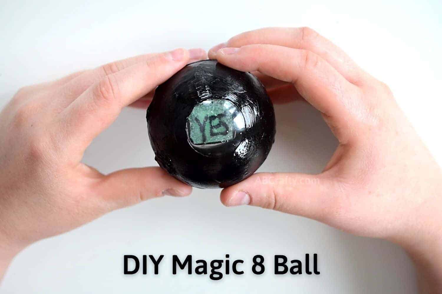 DIY Magic 8 Ball held in hands showing an answer of 'yes' with the words DIY Magic 8 Ball written on the image