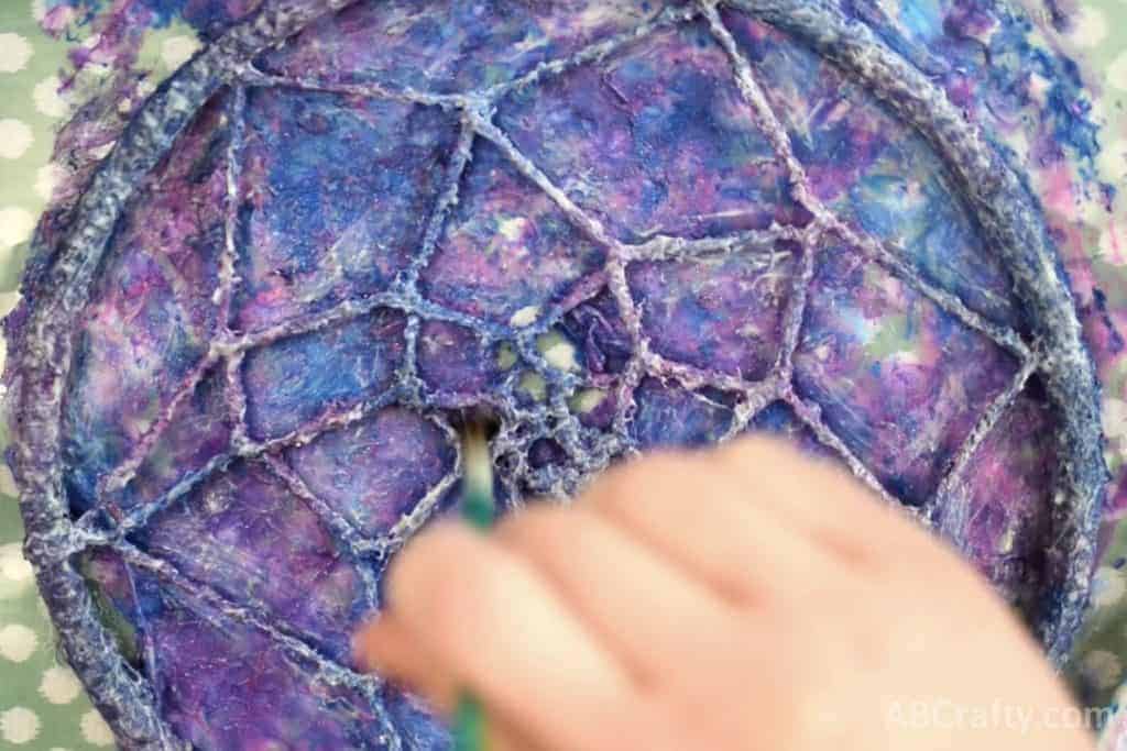 Painting the dream catcher with glow in the dark fabric paint