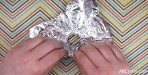 folding edges of the tin foil to make a wall