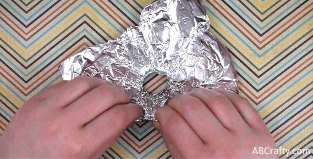 folding edges of the tin foil to make a wall