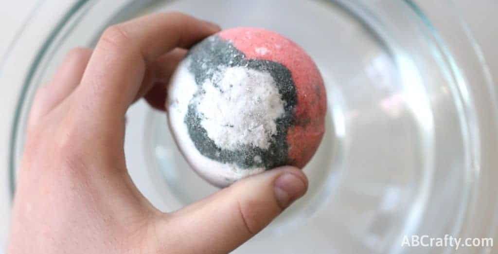 holding a bath bomb over water