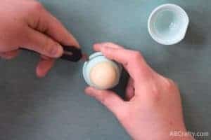 using an xacto knife to separate the parts of an EOS lip balm