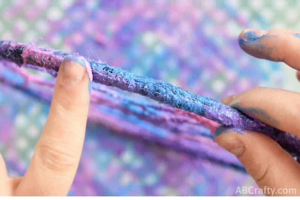 Using fingers to blend the colors of fabric paint to create galaxy effect