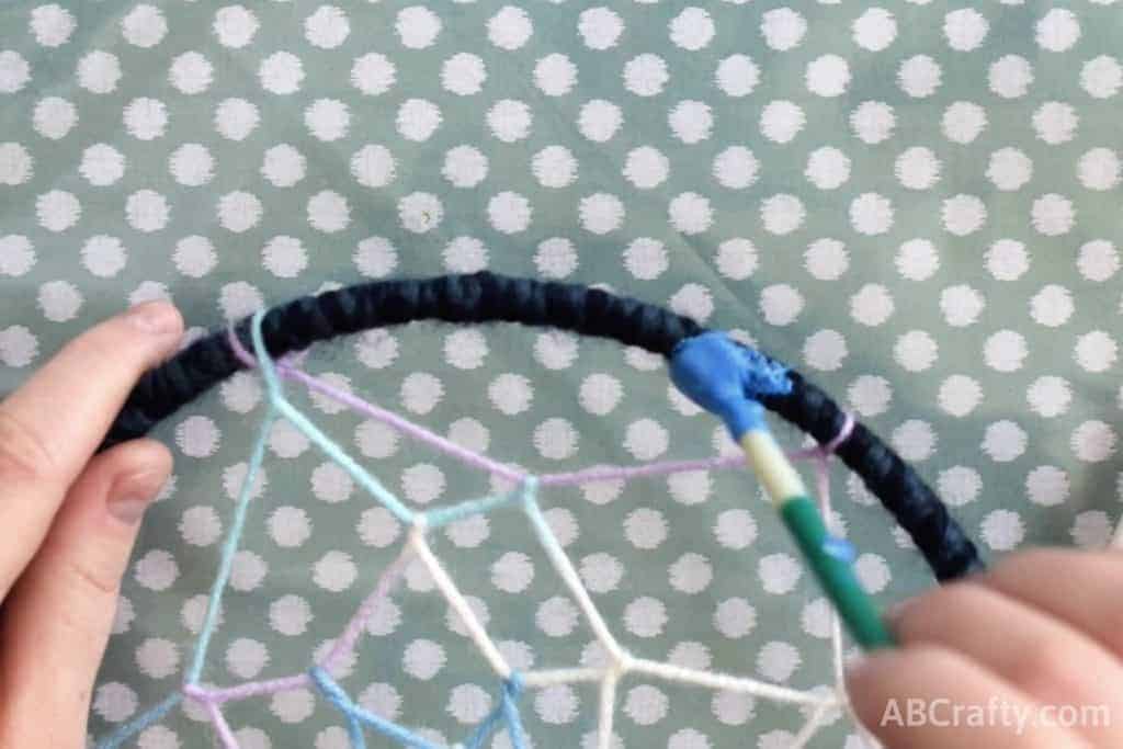 Starting to paint the yarn covered hoop with fabric paint