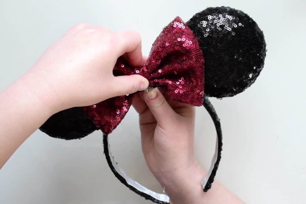 Adding red sequin bow to handmade light up minnie mouse ears
