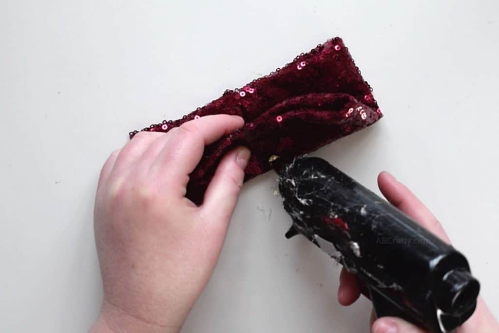 Adding glue to red sequin fabric