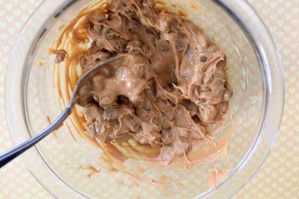 Peanut butter and dry dog food mixed together in a bowl