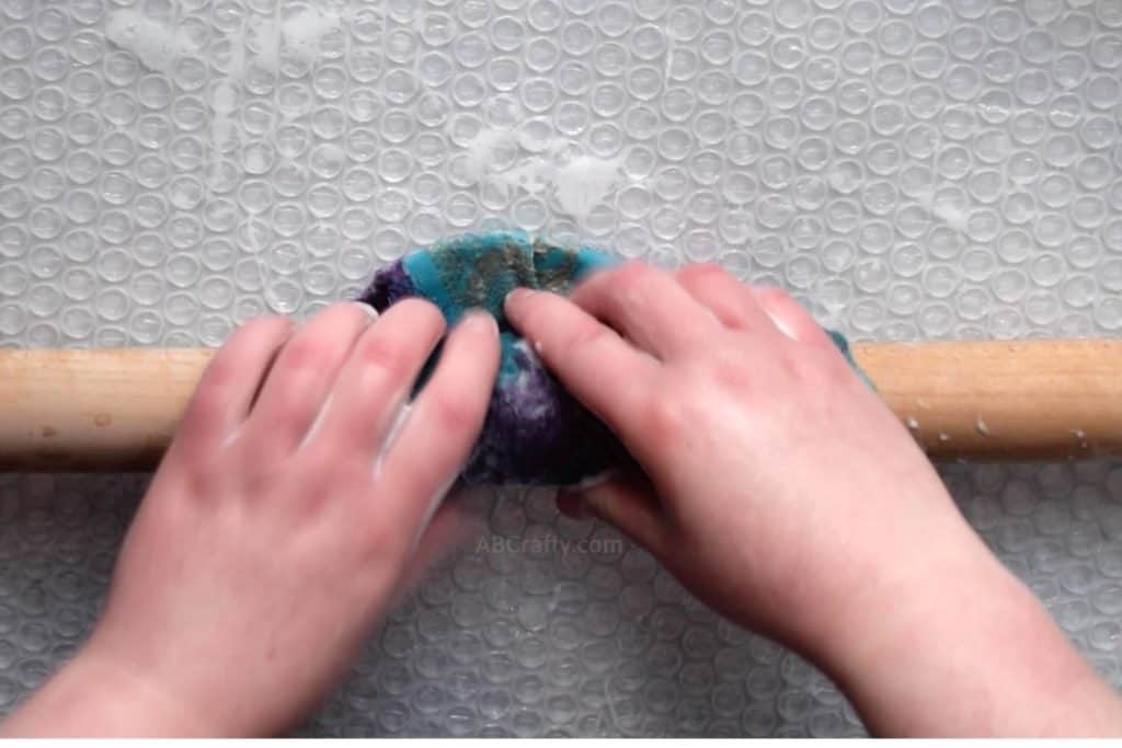 Rolling the wet felted project on a wooden dowel