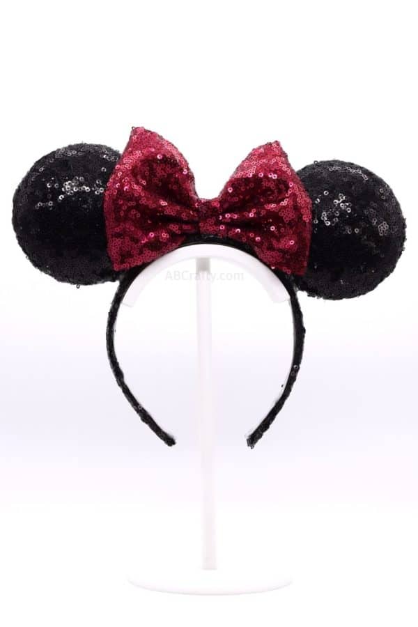 DIY Light Up Minnie Ears. It's a black sequined headband with a red sequined bow, creating the classic Disney Minnie Mouse ears