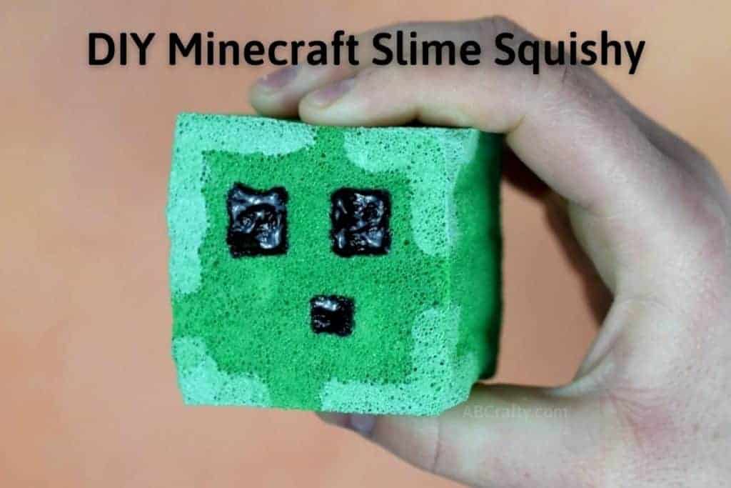 Holding finished DIY squishy in the shape of a Minecraft slime block with words "DIY Minecraft Slime Squishy"