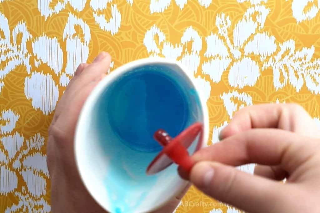 Dipping ring pop base into melted blue soap