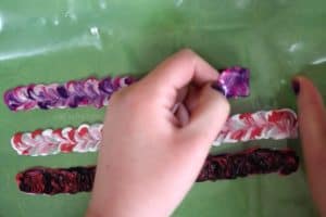 Peeling off stretchy fabric paint DIY bracelets from a plastic freezer bag