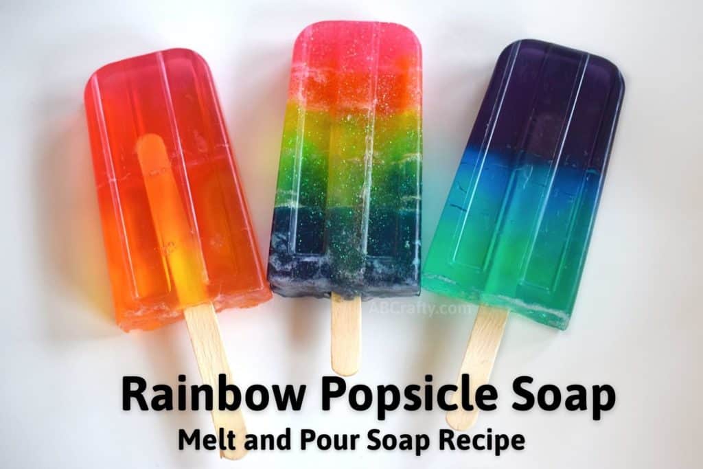 3 colorful popsicle soaps with popsicle sticks sticking out with the title 'Rainbow Popsicle Soap - Melt and Pour Soap Recipe"