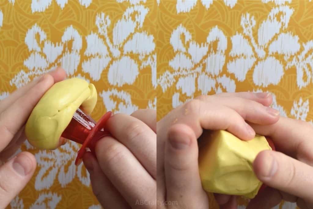 Squishing yellow putty around a red ring pop