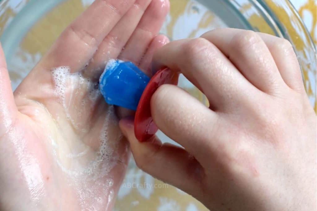 Using blue lollipop soap to wash hands with soap bubbles