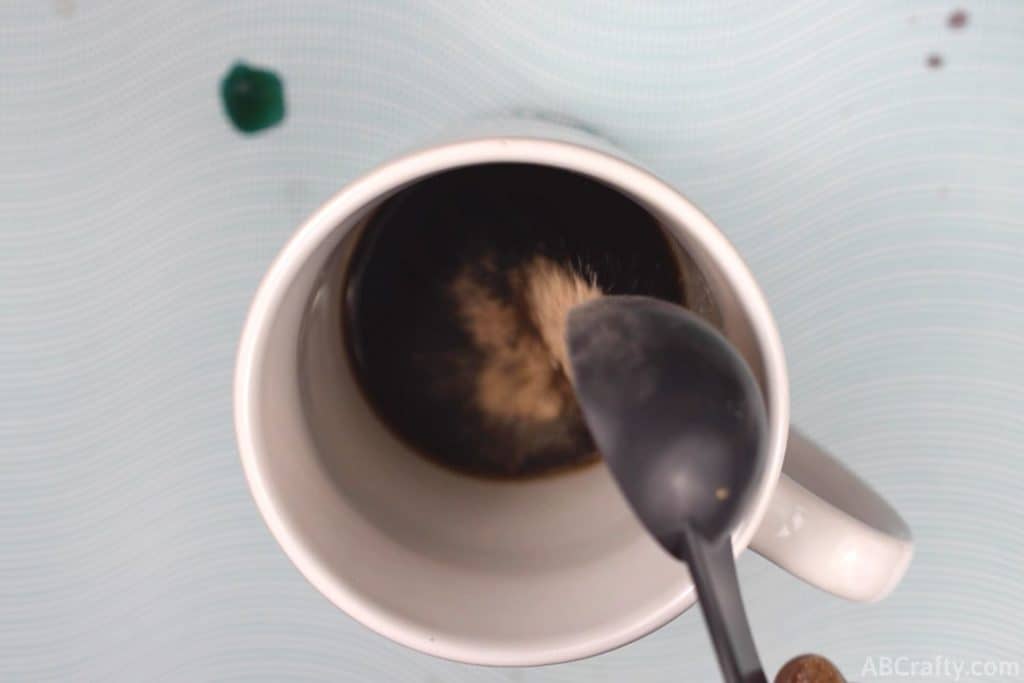 pouring fiber powder into a mug with coke zero