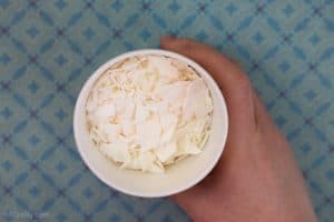 Holding a cup of soy wax flakes