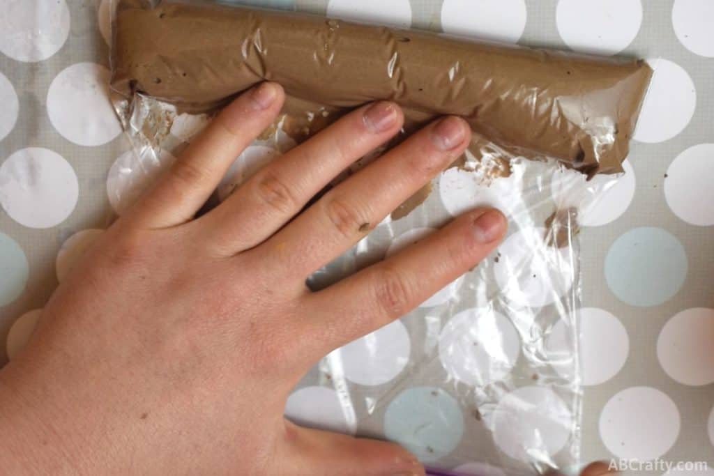 pushing thick brown chalk paste mixture to the end of a plastic ziplock bag