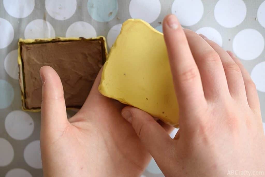 yellow silicone mold flipped over with one hand onto another hand