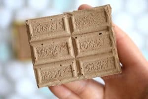 holding a diy sidewalk chalk in the shape of a chocolate bar