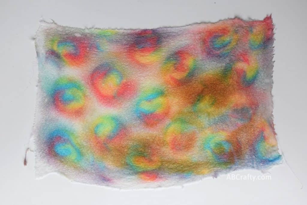 Completed dyed habotai silk with swirls of rainbow circles and brown splotches from the burnt candy