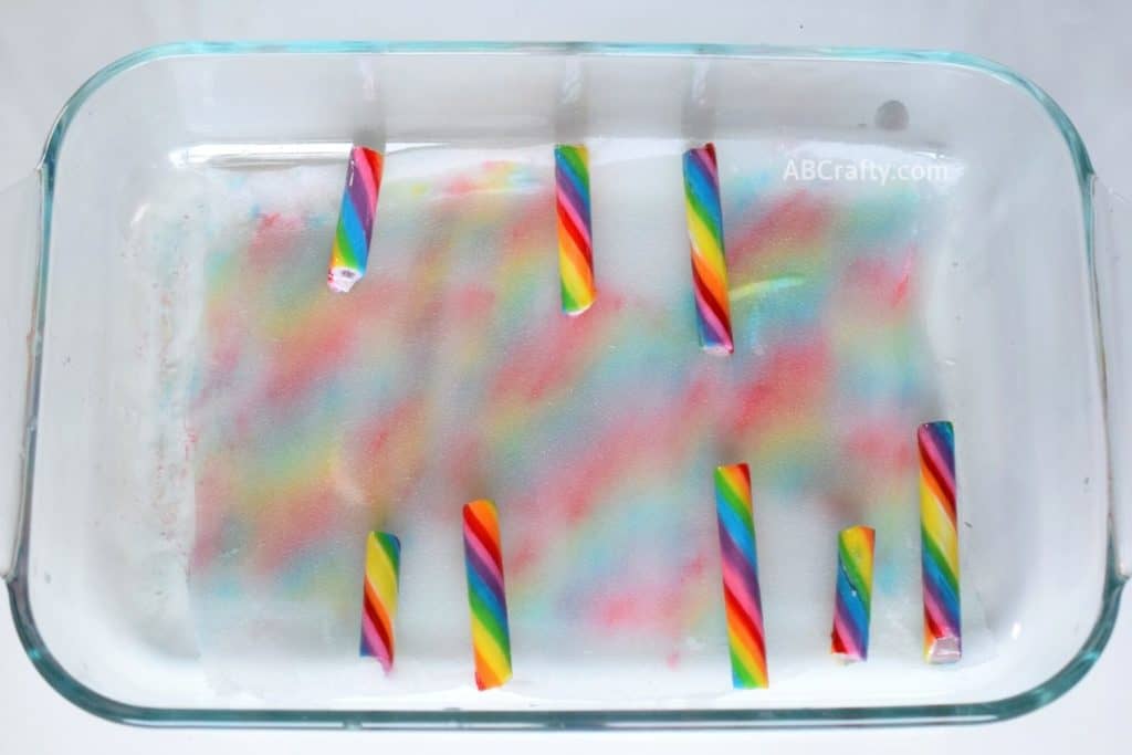 Small pieces of colorful candy sticks filling in the white space of of fabric getting colored by the food coloring from the candy