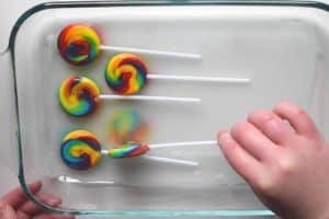 Lifting a small whirly pop up slightly to reveal a tie dyed silk print of the lollipop on the wet silk underneath