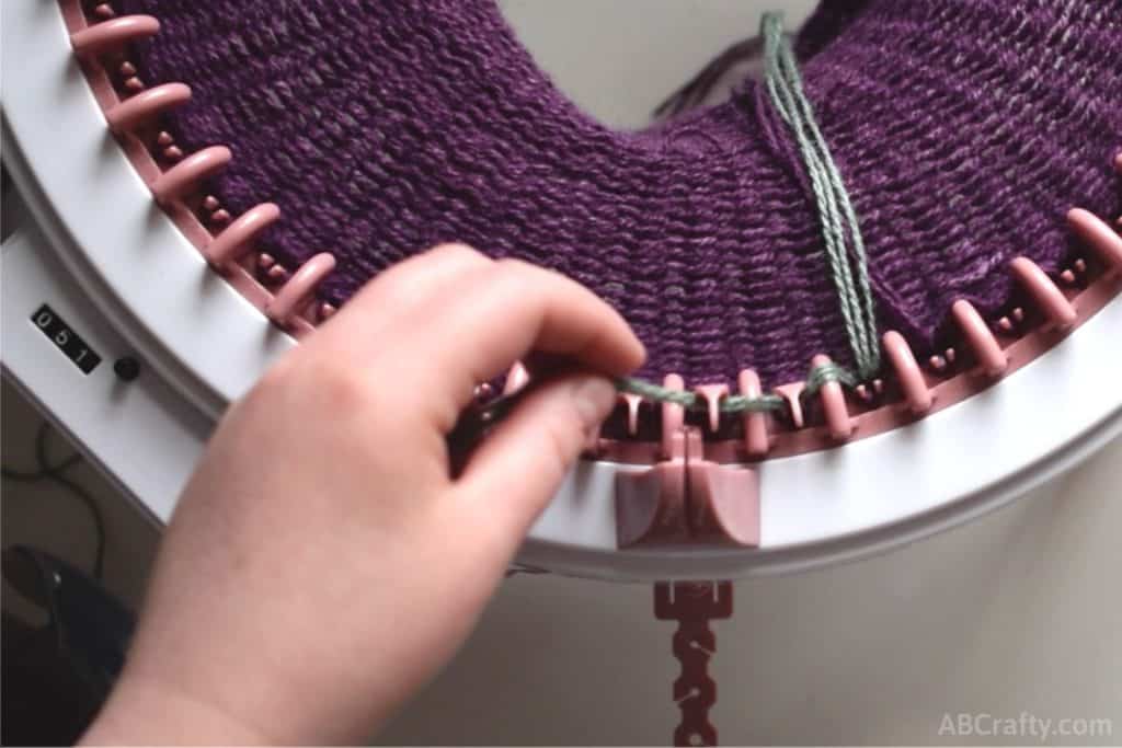 placing the green yarn in front of three needles on the sentro knitting machine