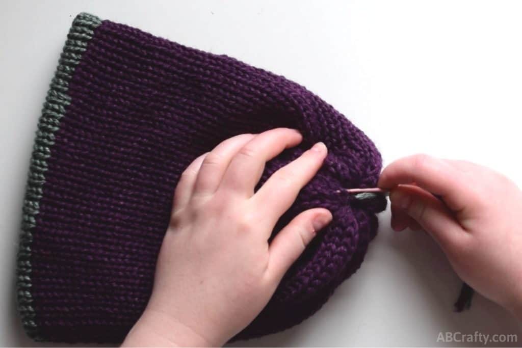 using the plastic needle to sew into the middle of the reversible knit beanie