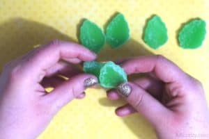 placing a cut green leaf gummy on top of another