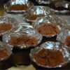 baked chocolate cupcakes in cone shaped tinfoil inside a cupcake tin