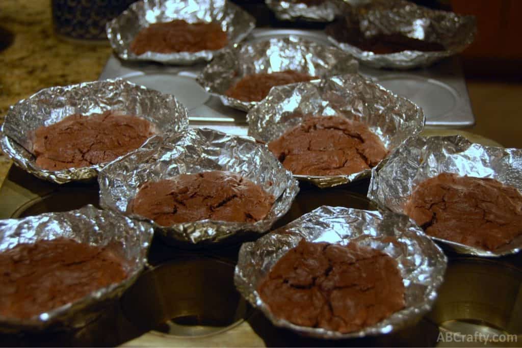 baked chocolate cupcakes in cone shaped tinfoil inside a cupcake tin