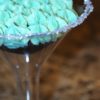 photo of half of a martini glass with a chocolate cupcake and green bailey's frosting with sugar on the rim
