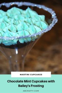 chocolate cupcake with green frosting inside a plastic martini glass with sugar rim. Title reads 'martini cupcakes, chocolate mint cupcakes with bailey's frosting, abcrafty.com'