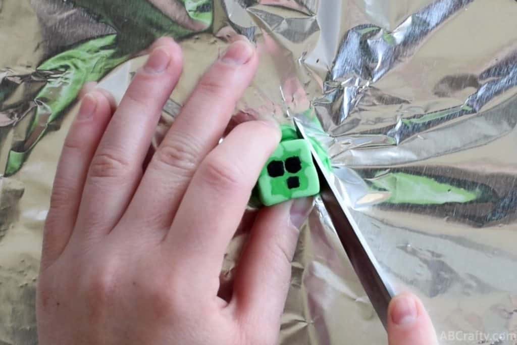 using a knife to cut off the edges of a minecraft eraser that looks like a slime chunk