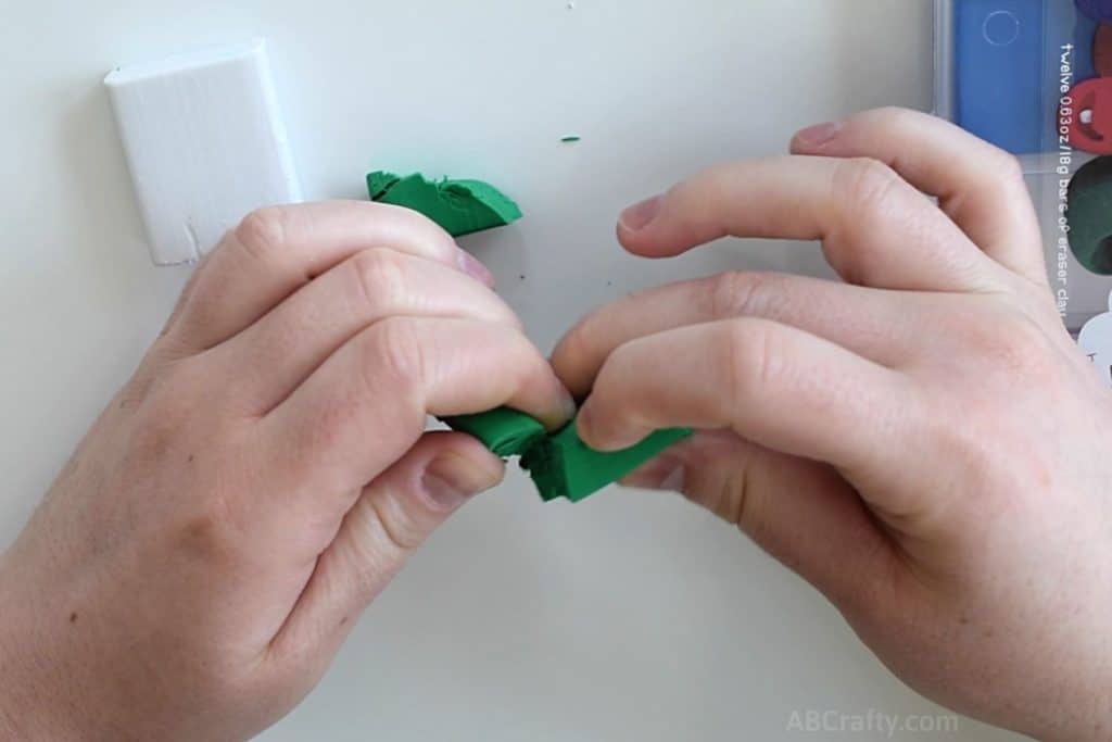 tearing off some green eraser clay from the creatibles diy eraser kit