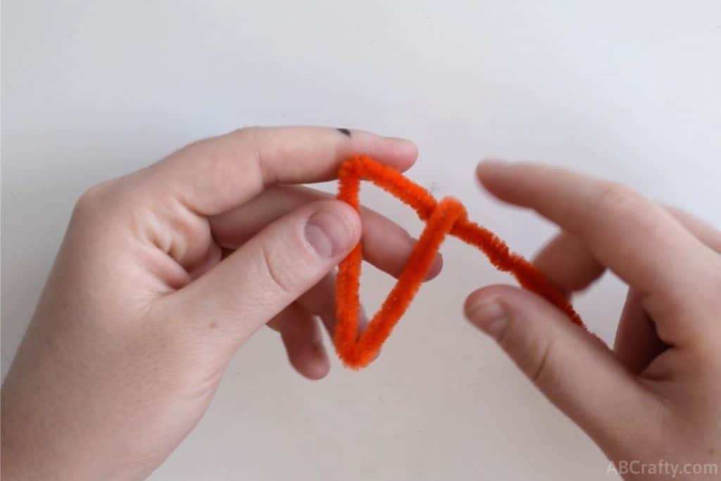 making a triangle with an orange pipe cleaner