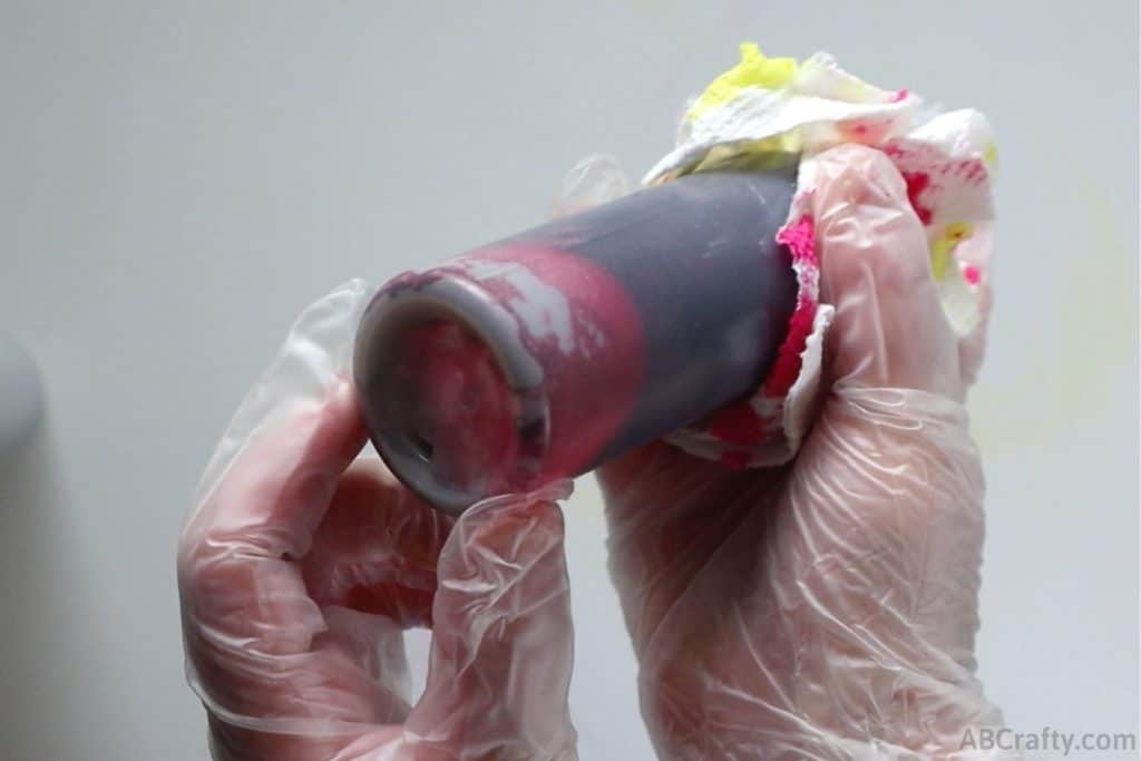 holding a bottle of red dye showing the dye powder at the bottom of the bottle