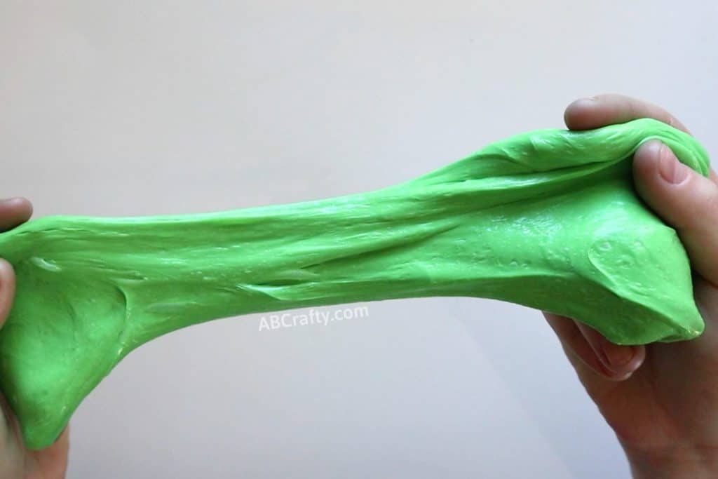 stretching classic green slime apart with two hands