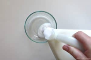 pouring white glue into a clear pyrex bowl