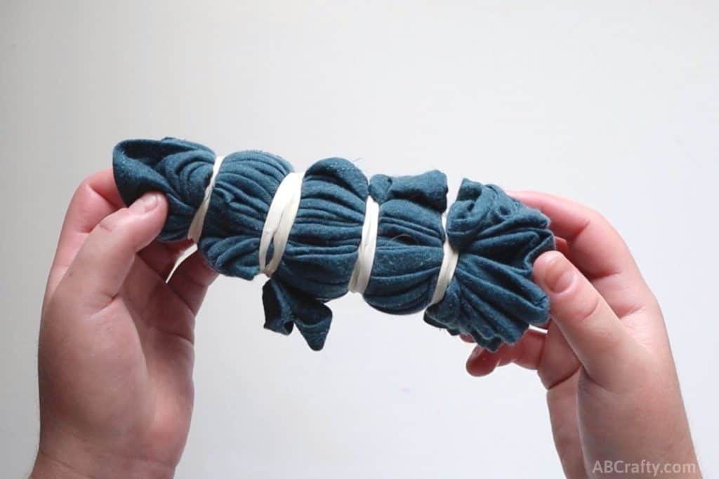 a blue tank top folded up and wrapped with four rubber bands