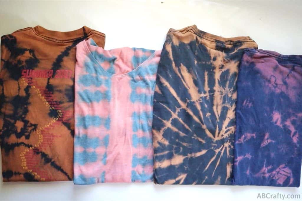 4 folded up reverse tie dye t shirts with different tie dye patterns