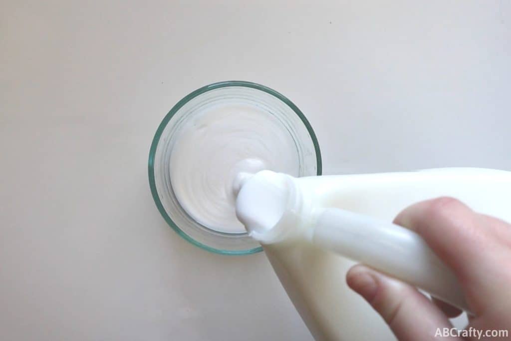 pouring white glue into a glass bowl