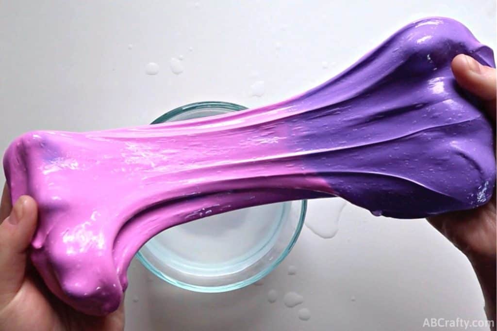 stretching color changing slime while showing the purple and pink colors