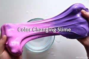 holding slime stretched out so that pink is one one side and purple is on another with the title "color changing slime"