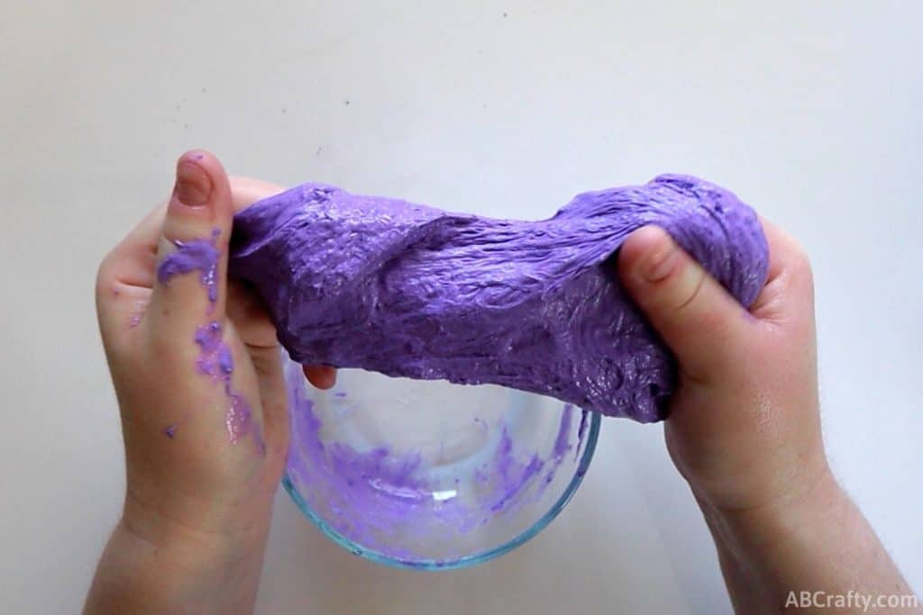 stretching chunky purple slime with hands