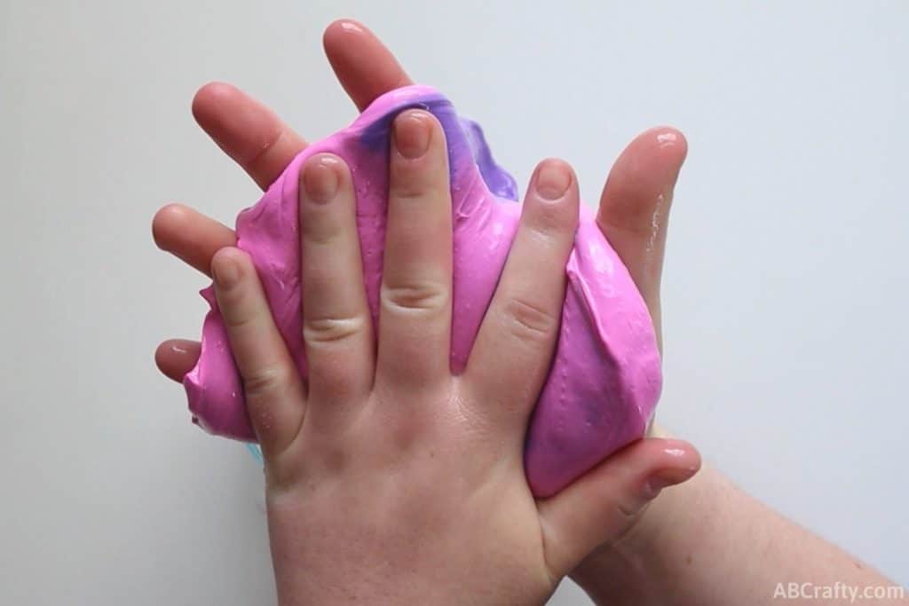 placing hand on pink color changing slime so it changes colors to purple