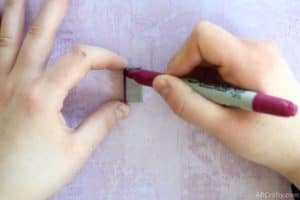 drawing a pink stripe onto staples with a permanent marker