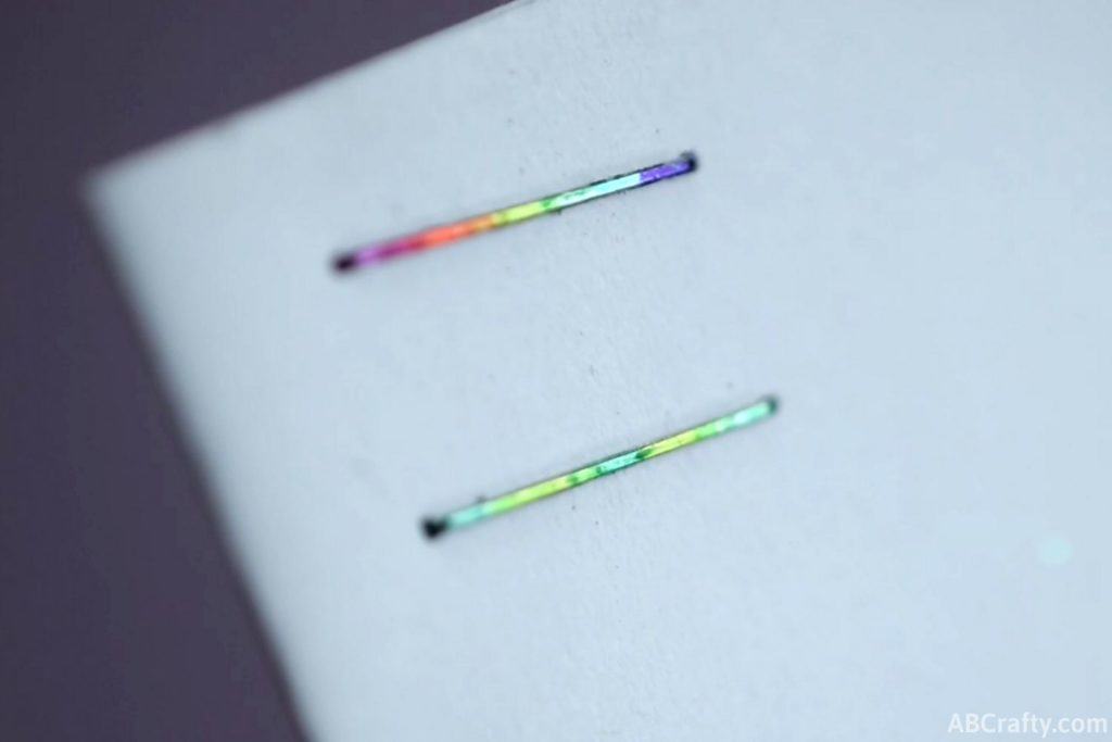 rainbow and green staple into a white piece of paper